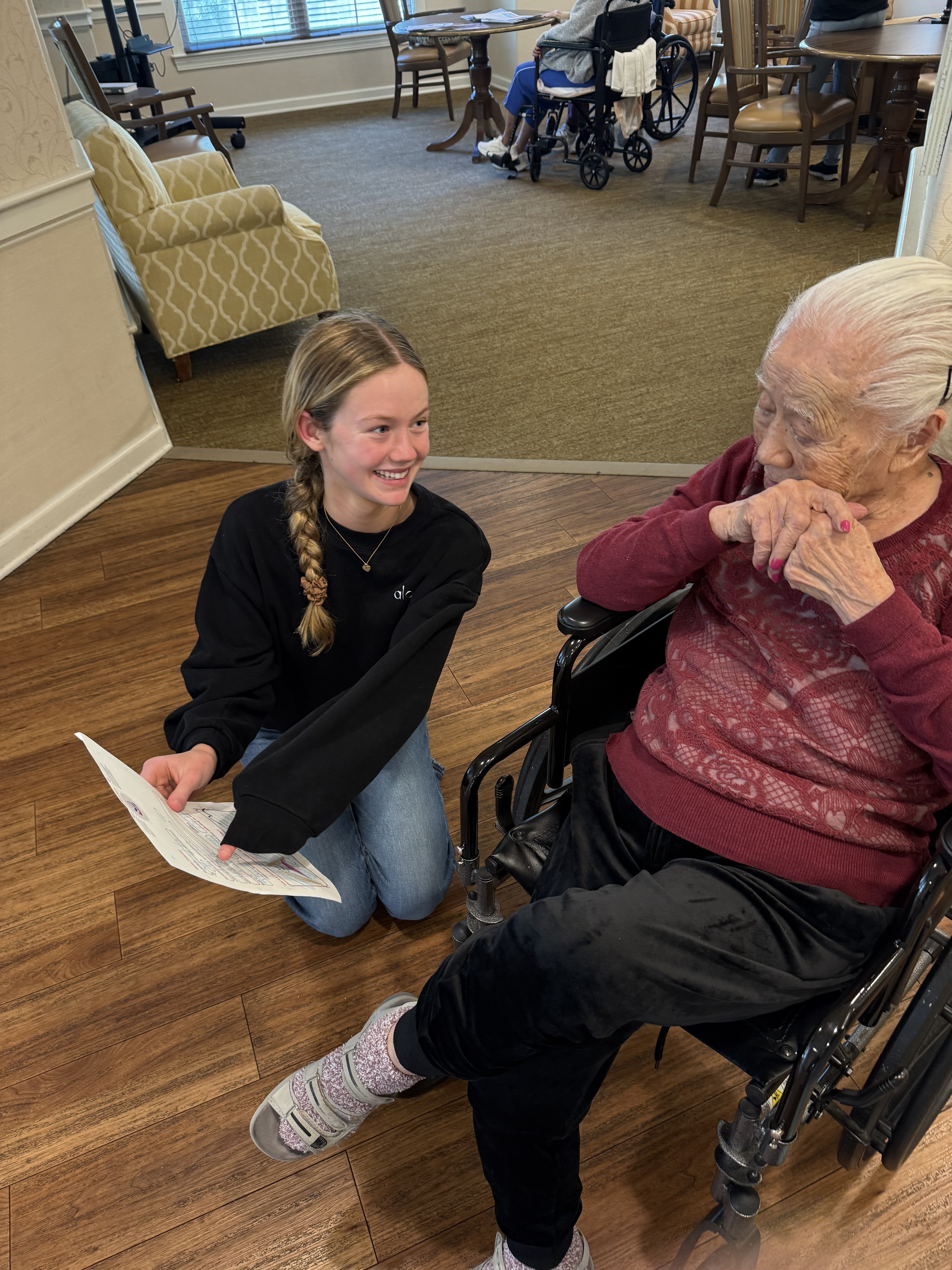 Grace smiling with a resident in a wheelchair at Ivy Park
