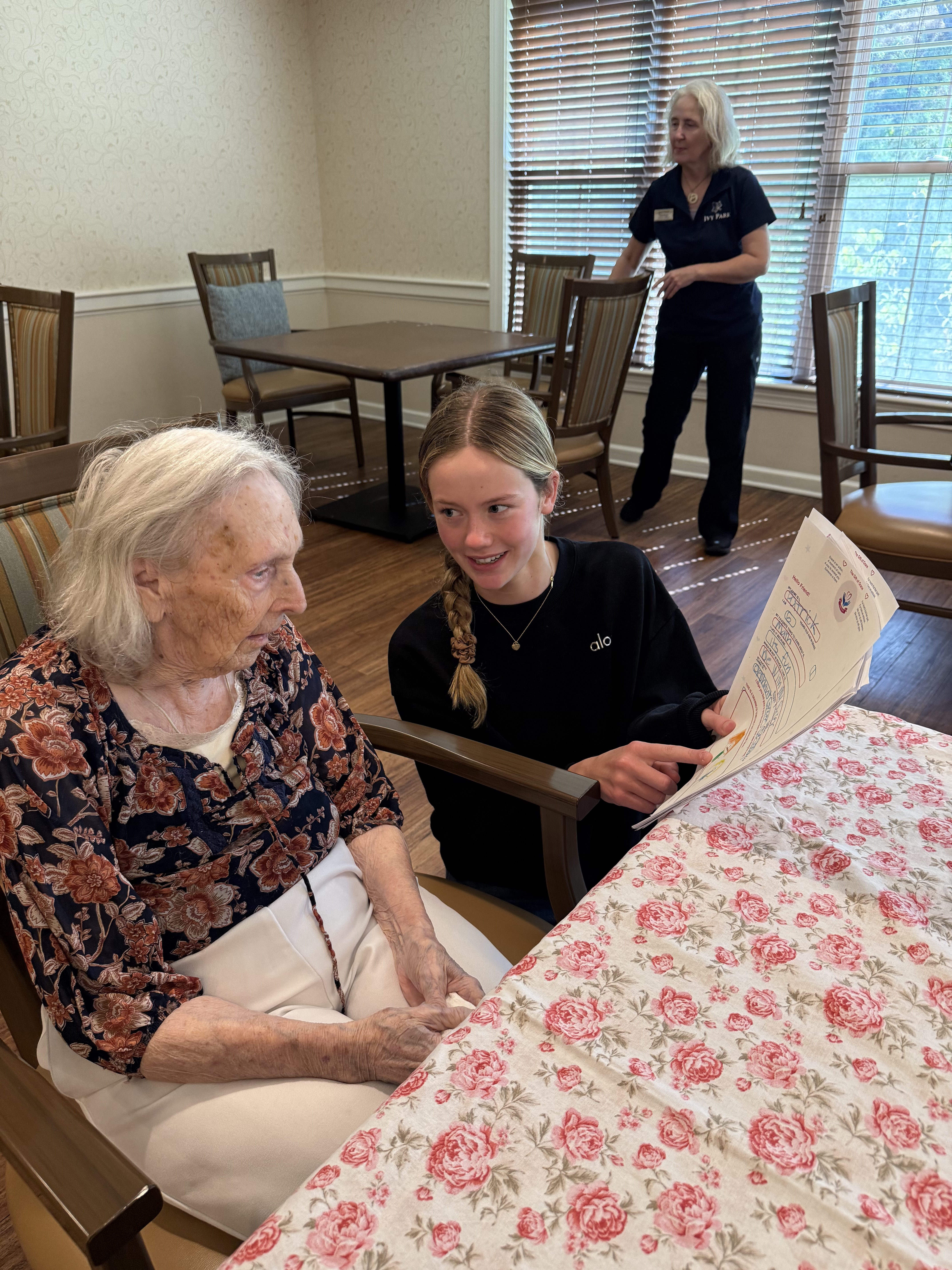 Grace reading a letter with a resident at Ivy Park