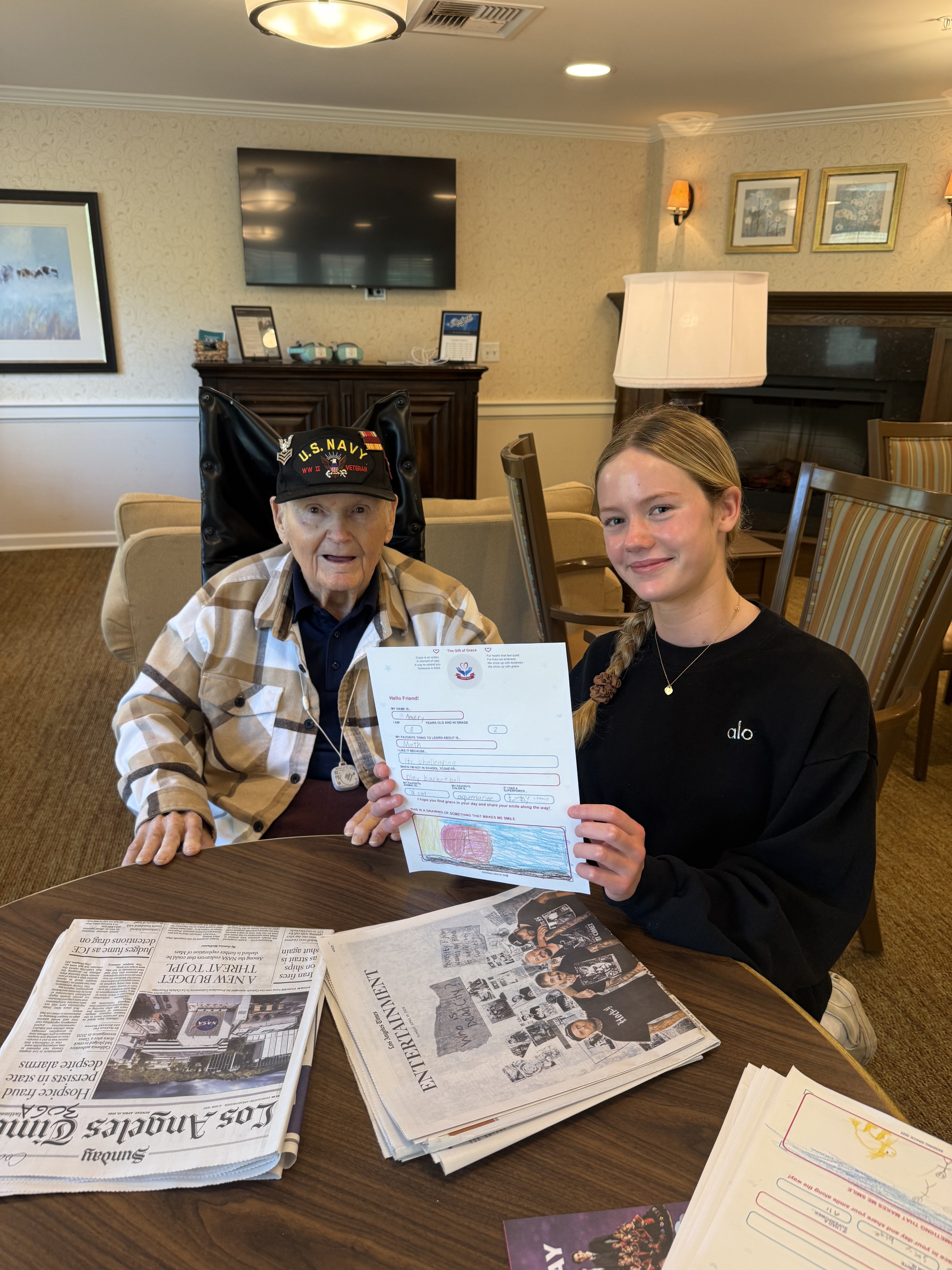 Coach, a WWII Navy veteran, holding a Sending Grace letter alongside Grace O'Rourke