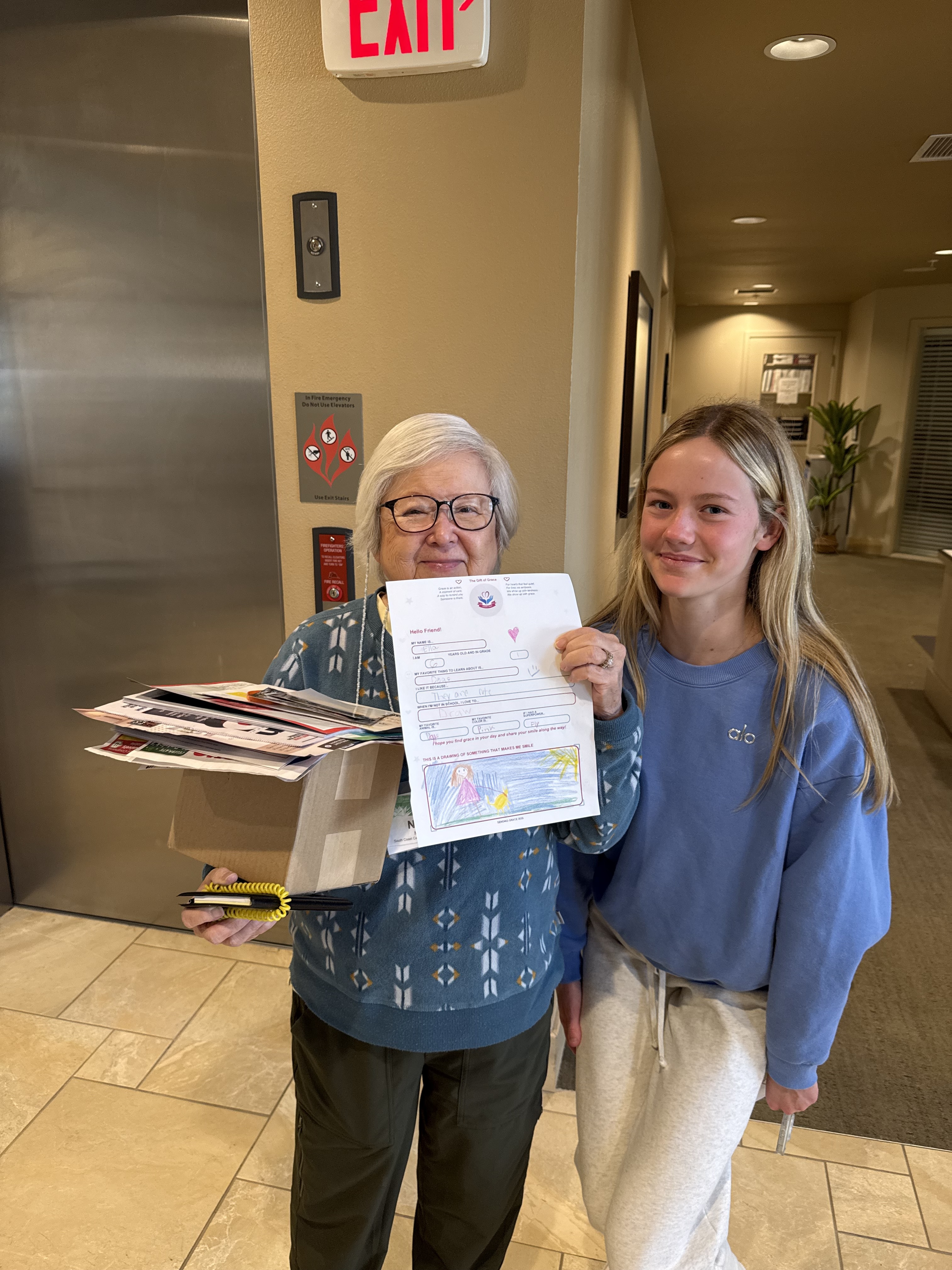 Shirley, a resident at a local care facility, holding a Sending Grace letter alongside Grace O'Rourke