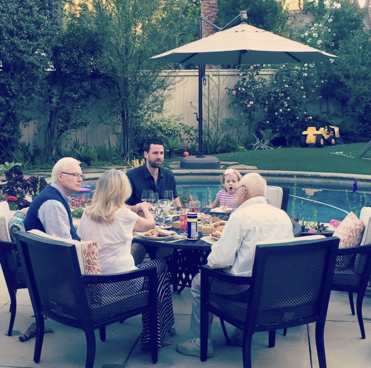 Grace at six at an outdoor dinner table with her grandparents, her dad, and Mr. Peck