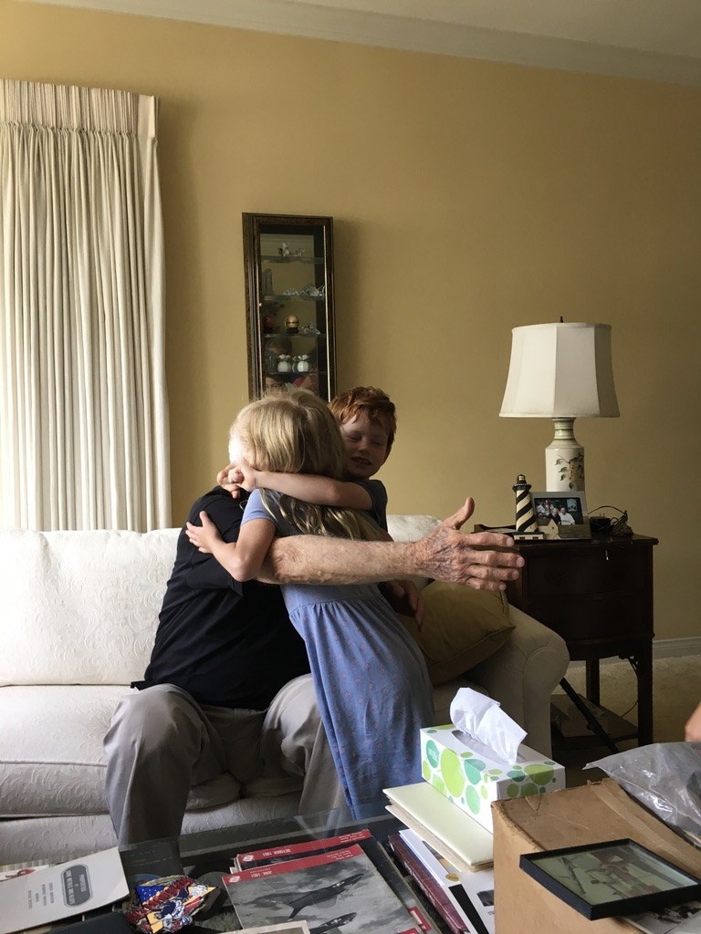 Grace as a young girl hugging her neighbor, Mr. Peck, in his living room