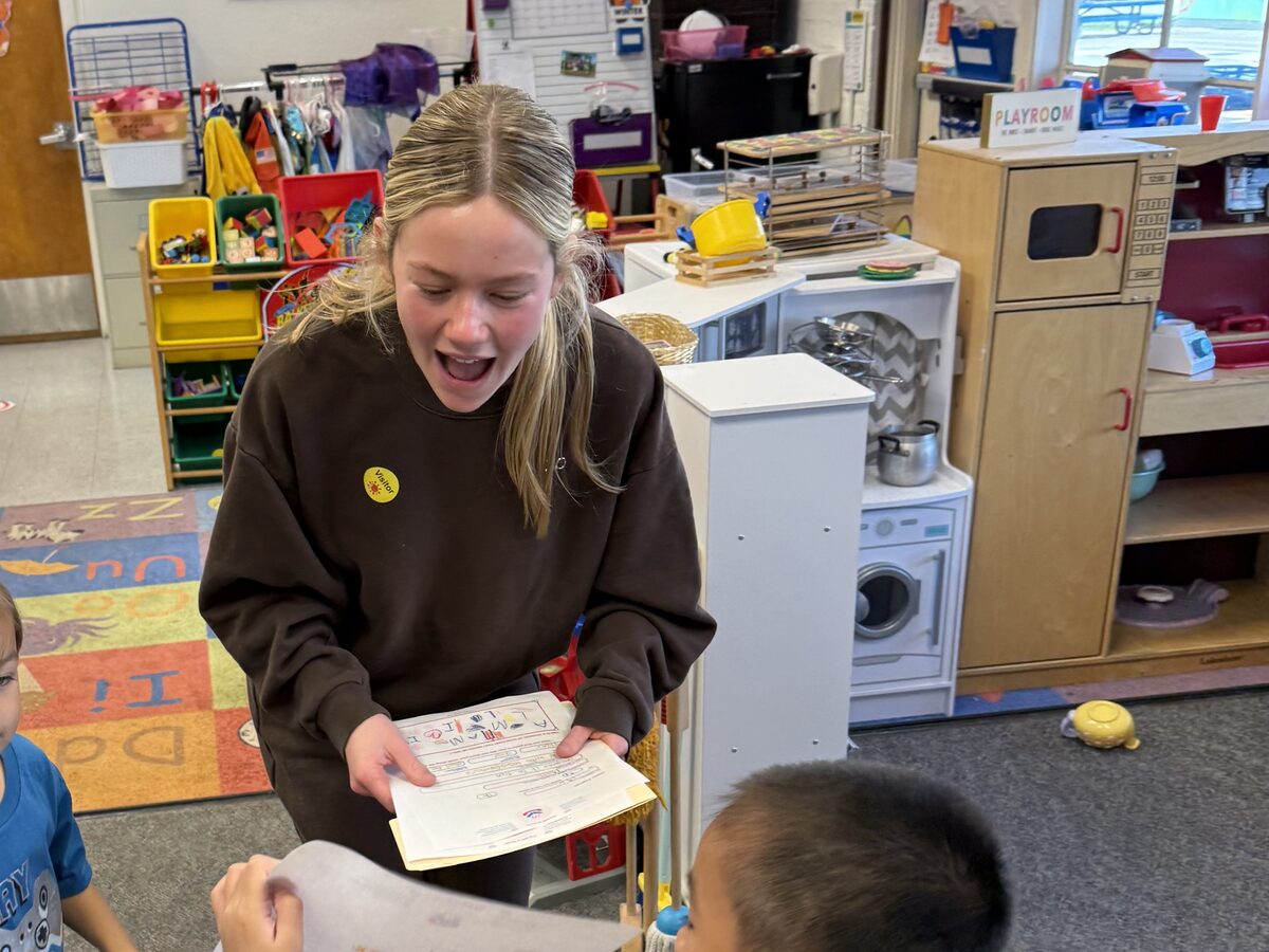 Grace collecting completed letters from students